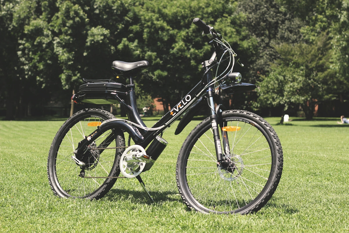 a bicycle parked in the grass in a park